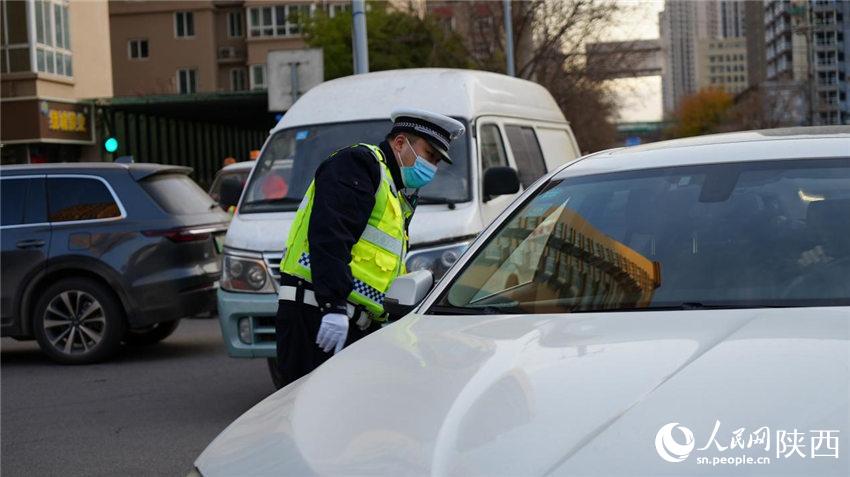 執(zhí)勤交警為群眾講解防疫政策。