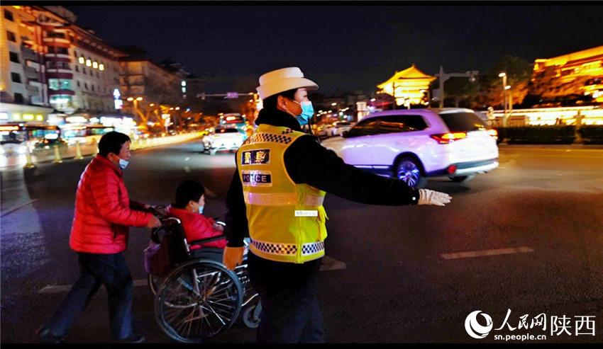 西安交警蓮湖大隊(duì)民警引導(dǎo)群眾過馬路。