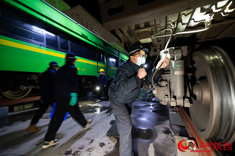 1月26日，西安客車車輛段，鐵路檢修“小哥”正在檢查動力集中型動車組走行部件。劉翔攝