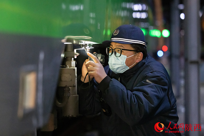 1月26日，西安客車車輛段，鐵路檢修“小哥”正在檢查動力集中型動車組注水口保證旅客正常用水。劉翔攝