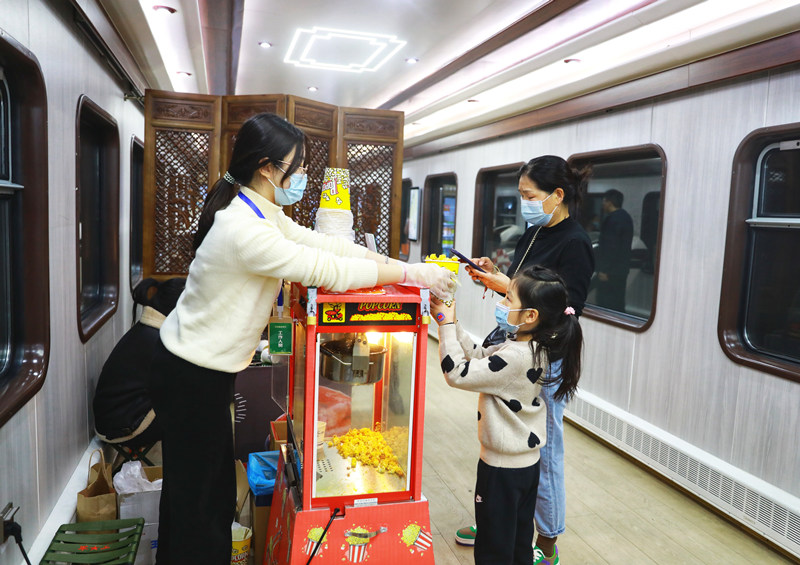 旅客們在列車上購買爆米花。敬雨橋攝