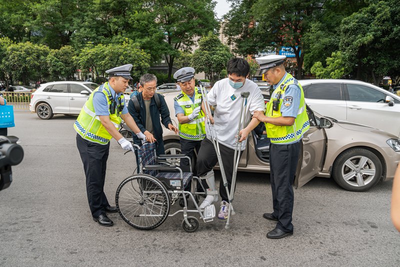 考生坐輪椅赴考，西安交警合力護送。孫崇明 攝