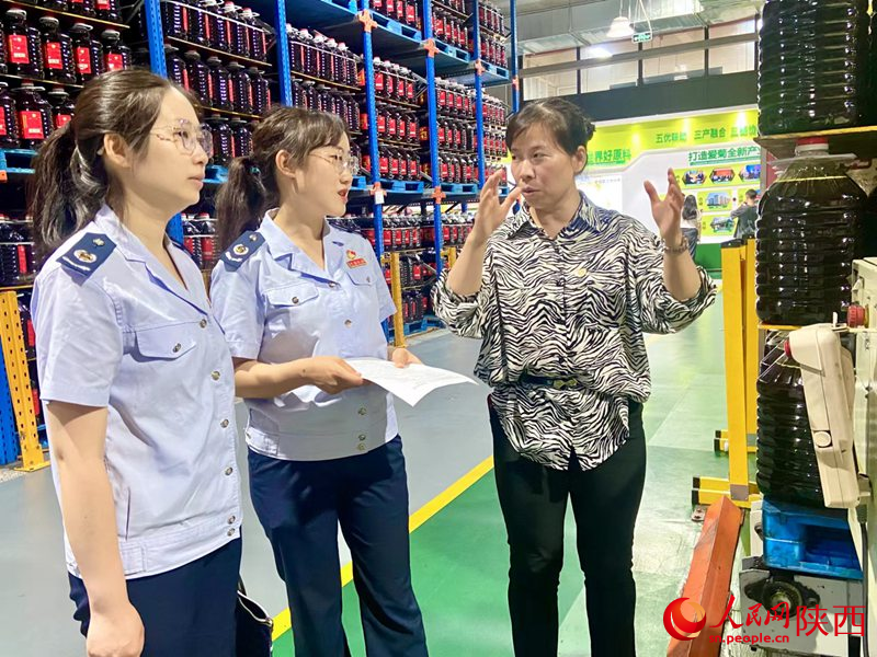 西安市稅務(wù)局青年干部道愛菊糧油集團(tuán)有限公司送政策。人民網(wǎng)記者王晴垣 攝