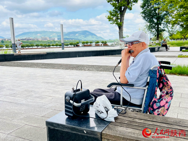 94歲的張大爺每天都會到天漢濕地公園憩息吹口琴。人民網(wǎng)記者 孫挺攝