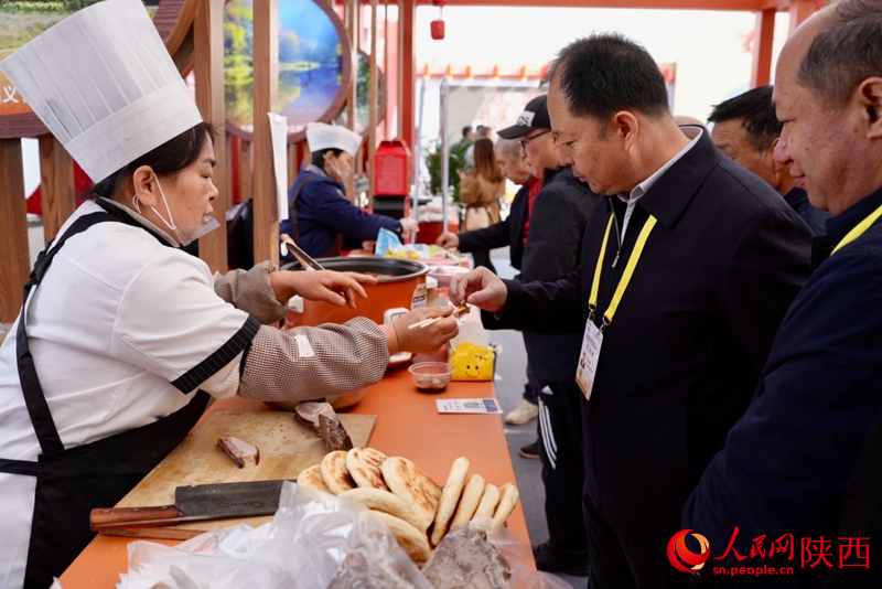 參展觀眾在渭南展館品嘗特色美食。人民網(wǎng)記者 鄒星攝