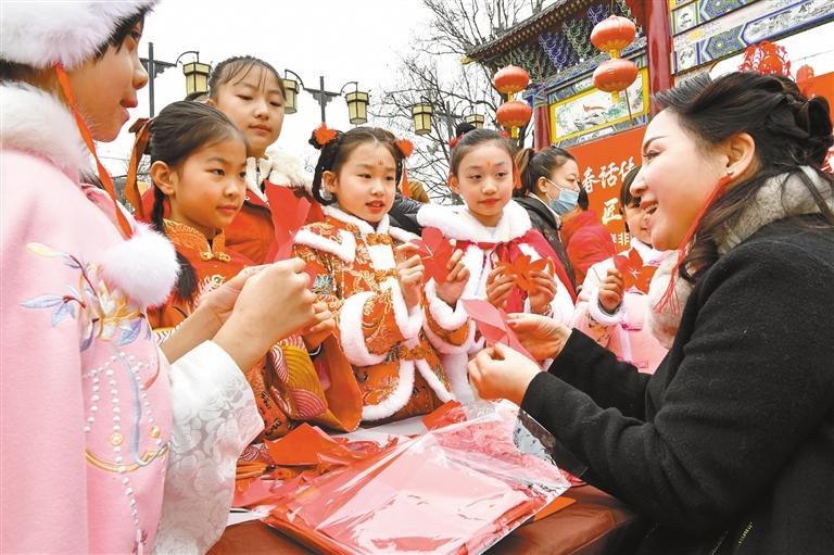 1月20日，西安永興坊·陜西非遺文化特色街區(qū)內(nèi)，非遺傳承人給孩子們教授剪紙、捏面人等非遺技藝。杜瑋攝