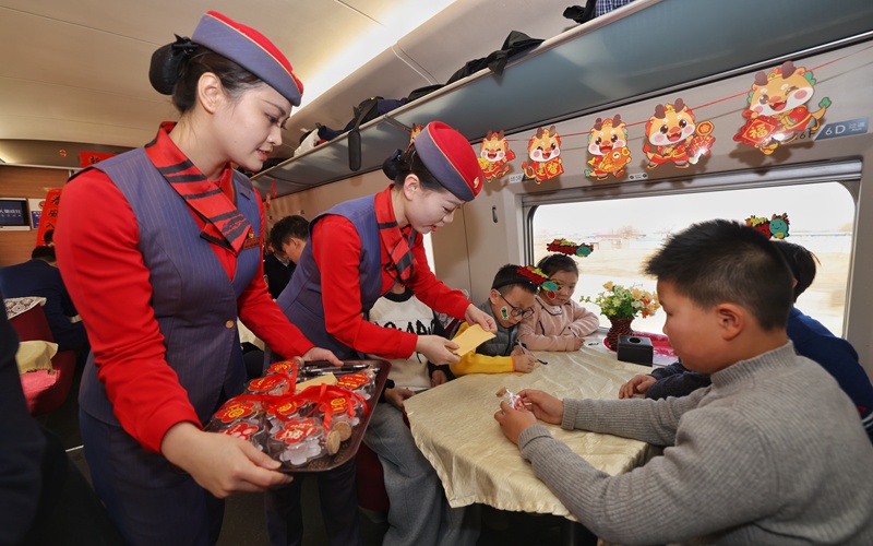 列車工作人員為小旅客們介紹“新春傳福漂流瓶”活動(dòng)。劉松霖 攝