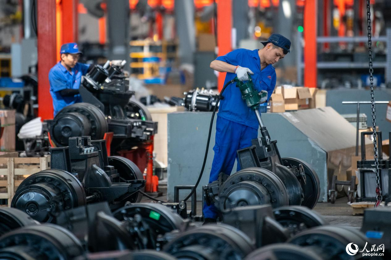 5月14日，在總裝車間，工人正在進(jìn)行非公路寬體自卸車底盤裝配作業(yè)。人民網(wǎng)記者 翁奇羽攝