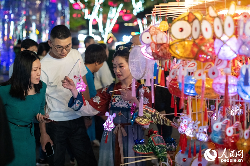 在西安大唐不夜城步行街，游客正在選購手工藝品。人民網(wǎng)記者 翁奇羽攝