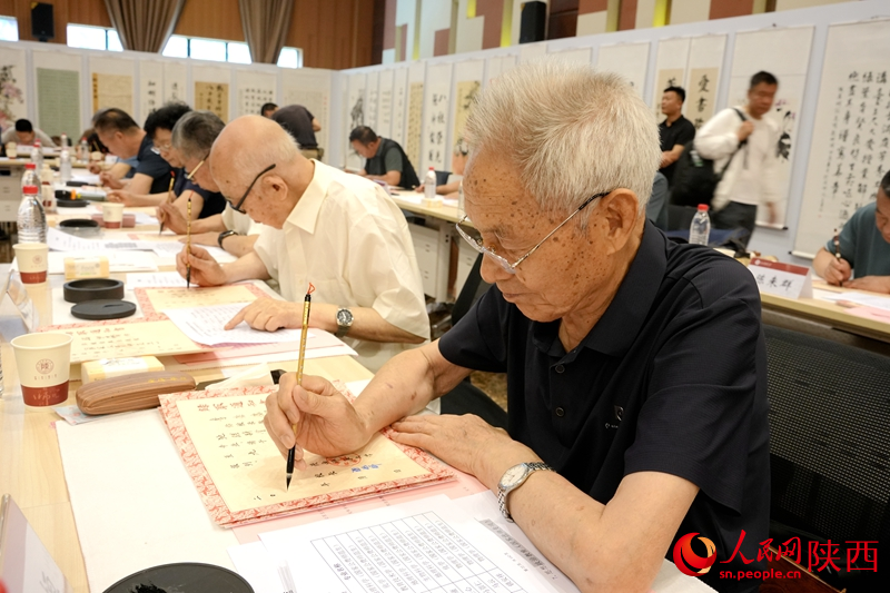 退休教師用毛筆書寫2024級(jí)新生錄取通知書。人民網(wǎng)記者 賈凱璐攝