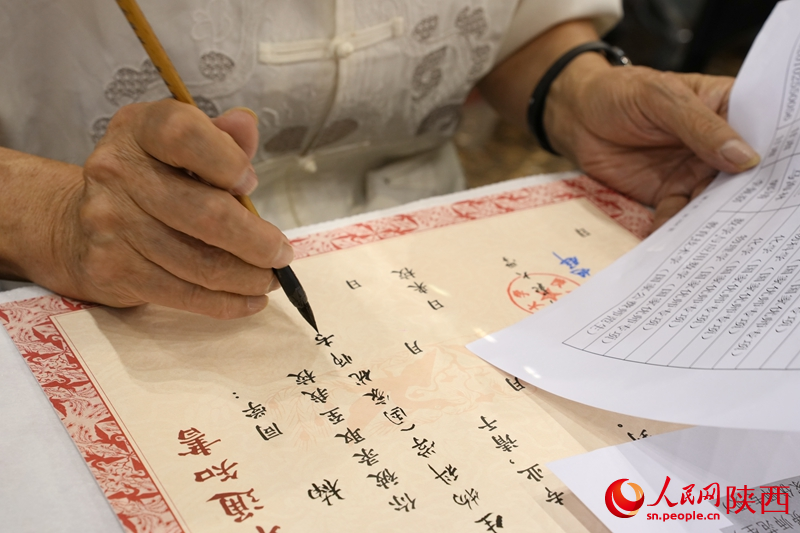 退休教師用毛筆為今年新生手寫(xiě)錄取通知書(shū)。人民網(wǎng)記者 賈凱璐攝