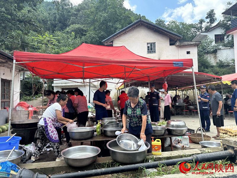 村民在應(yīng)急救援服務(wù)點為救援人員做后勤保障工作。人民網(wǎng)記者 李志強攝